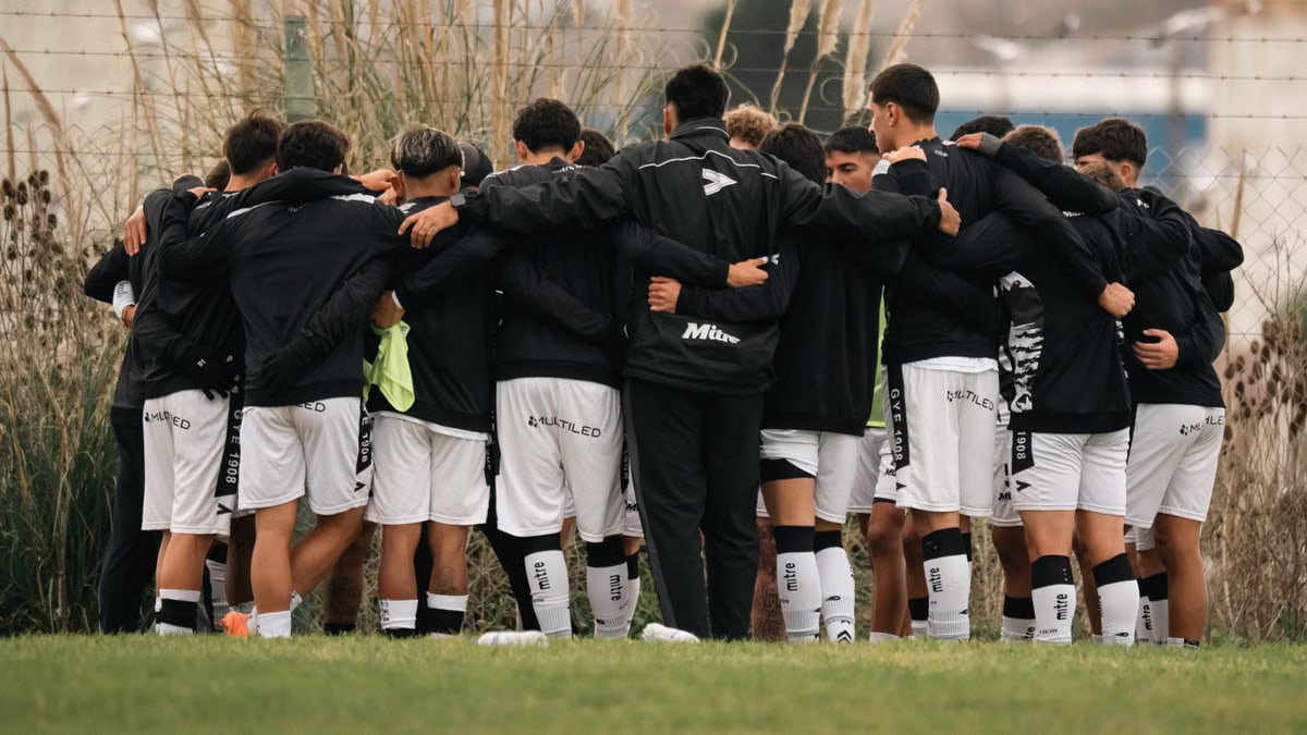 A group of soccer players in a huddle before a match, symbolizing teamwork and unity.
